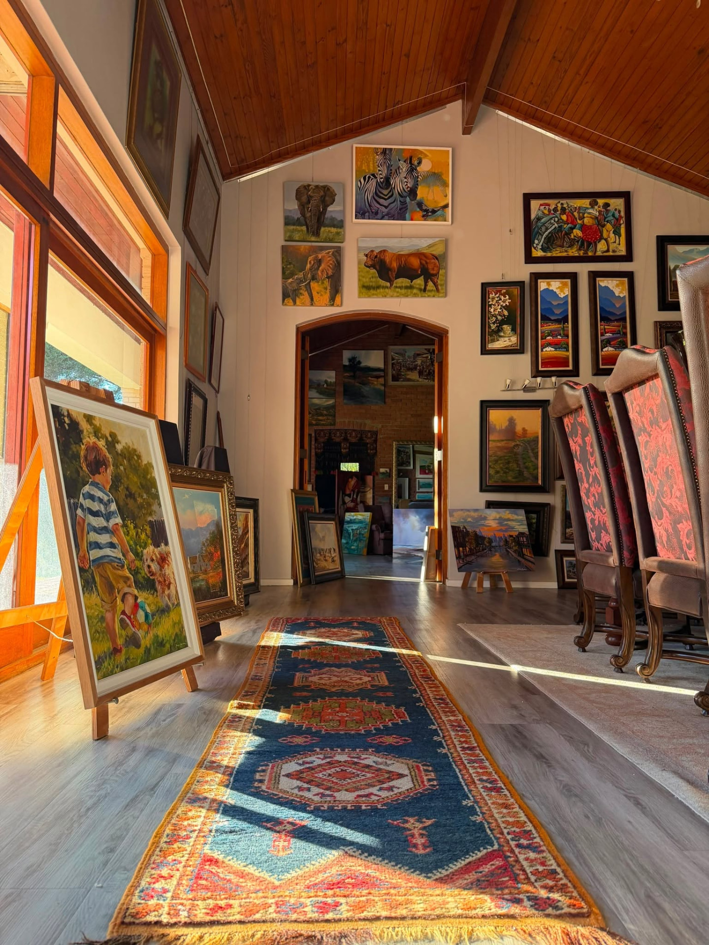 A detail inside Kunssinnig Gallery: framed works, furniture and warm interior light