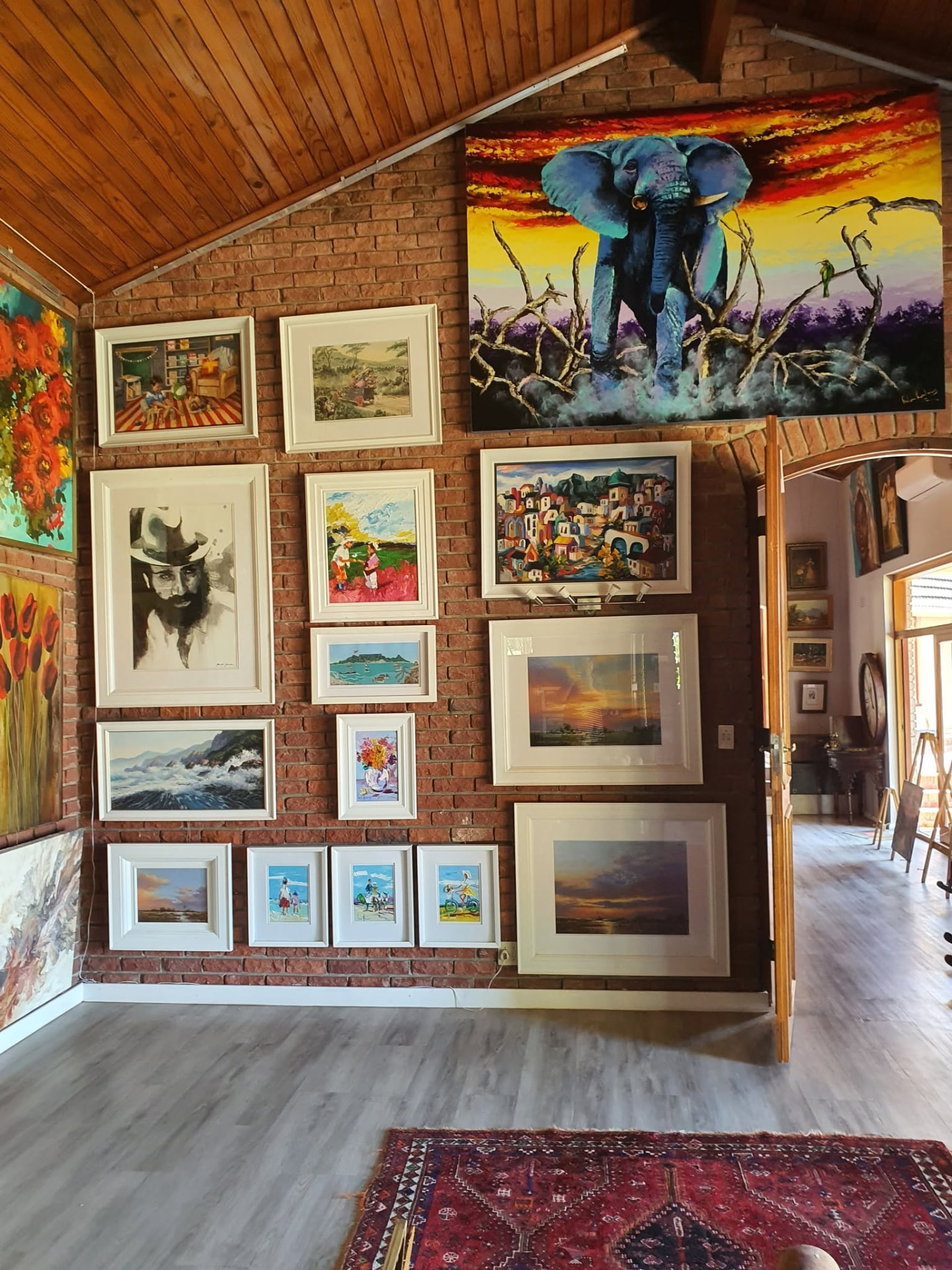 A passage inside Kunssinnig Gallery lined with framed South African paintings